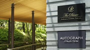 A building facade with signage for "The Prince Sakura Tower Tokyo" and "Autograph Collection."