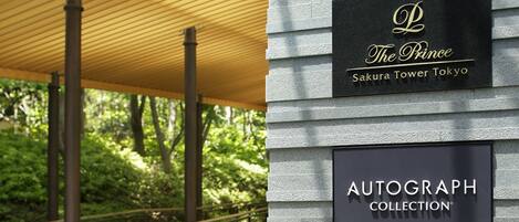 A building facade with signage for "The Prince Sakura Tower Tokyo" and "Autograph Collection."