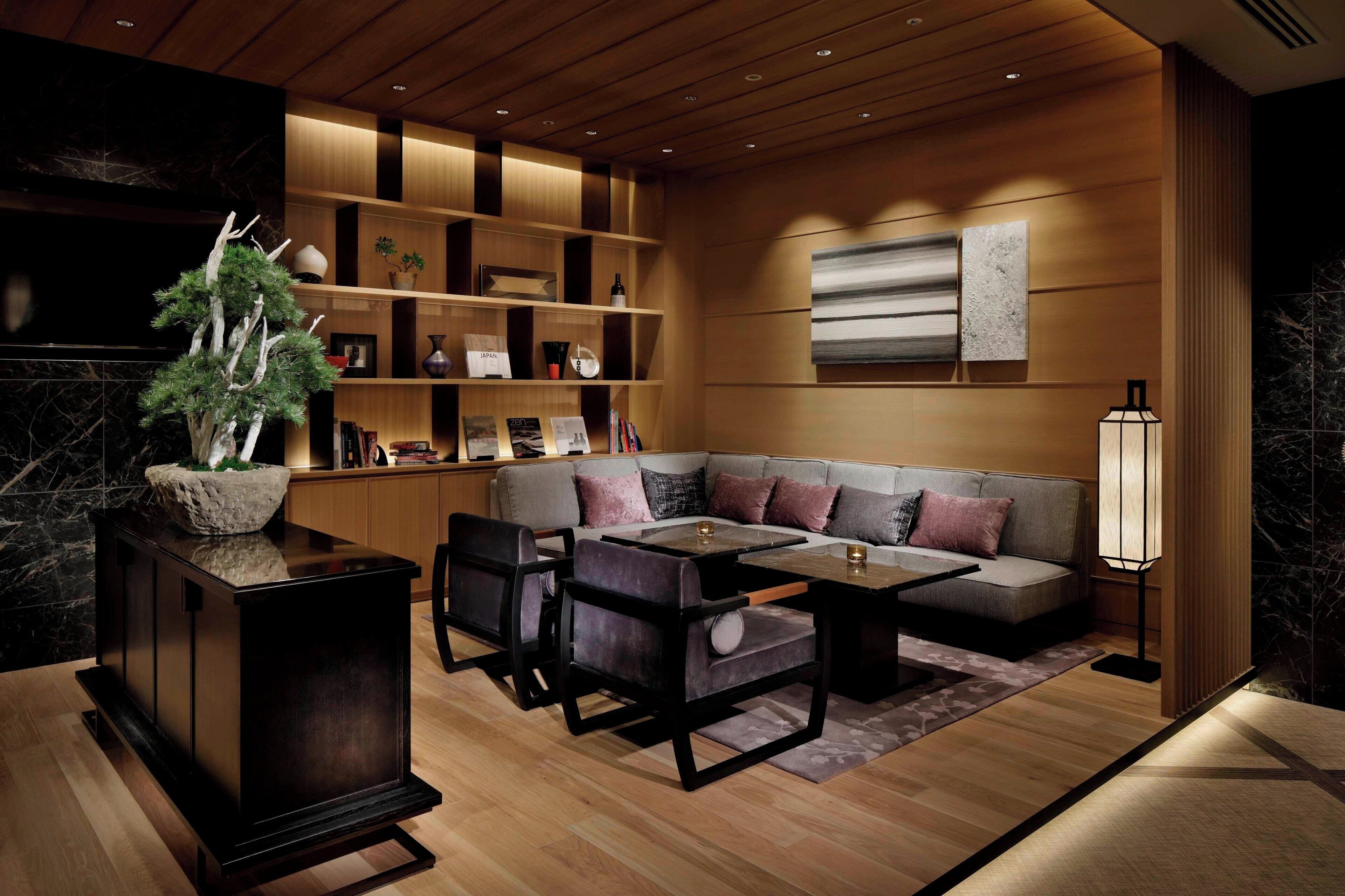 A modern living room with a sectional sofa, dark wooden furniture, and a decorative plant.