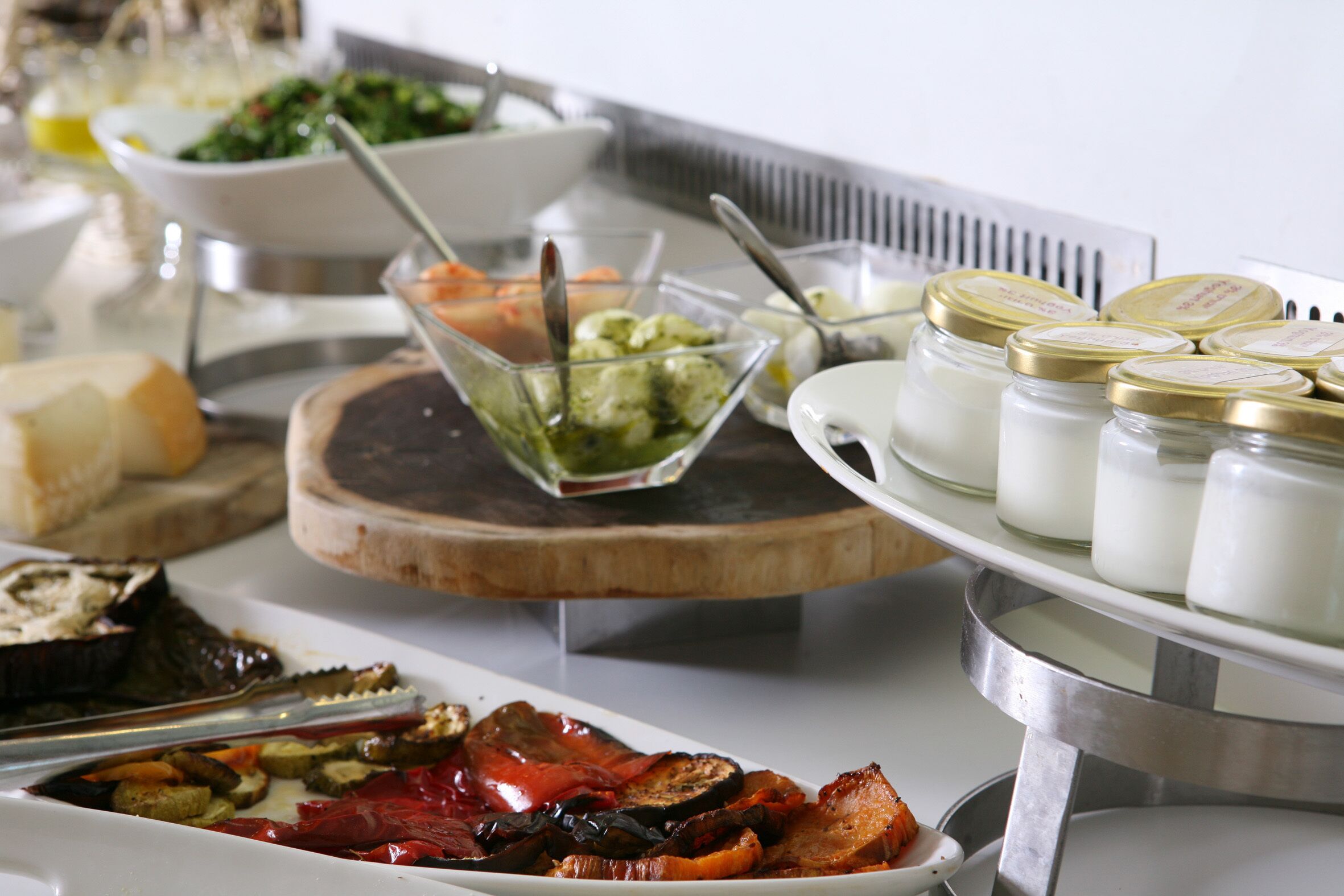 Un bufé con diversos alimentos, incluyendo verduras, carnes y productos lácteos.