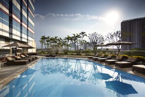 Una piscina al aire libre, sillones reclinables de piscina