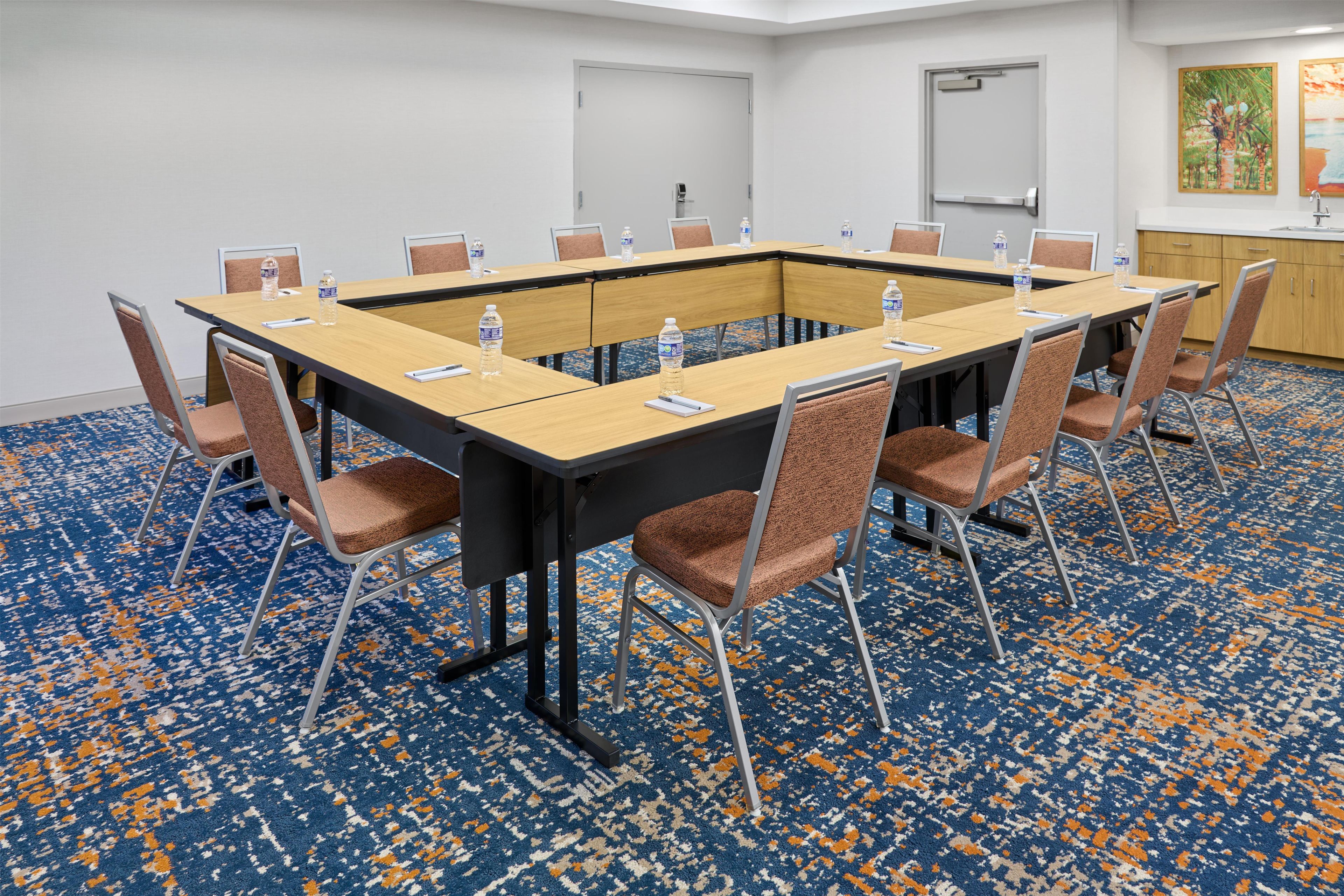 A conference room with a long table, chairs, and water bottles.
