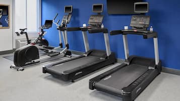 A gym with treadmills, an elliptical, and a stationary bike.