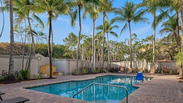 Een buitenzwembad en ligstoelen