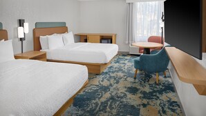 Une chambre d’hôtel avec deux lits, un bureau, une chaise, une télévision et une fenêtre avec des rideaux.