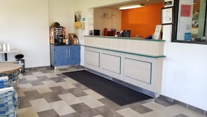 A hotel reception area with a coffee machine, a phone, and a counter. - FairBridge Inn Express London (London)