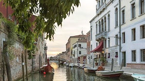 A canal with boats, buildings, and a bridge. - NH Collection Venezia Grand Hotel Dei Dogi (Venice)