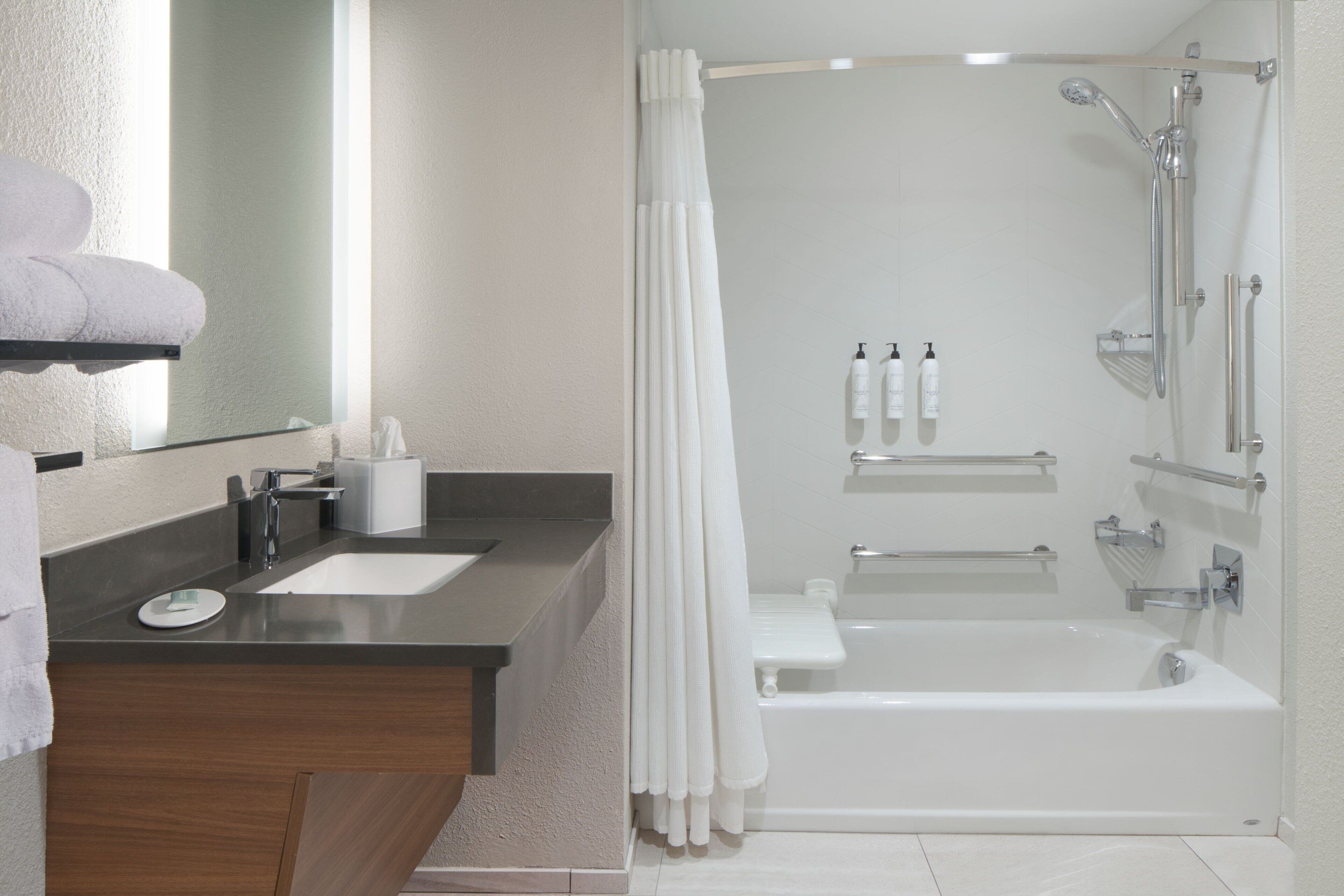 A modern bathroom with a bathtub, shower, and two sinks.