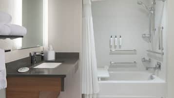 A modern bathroom with a bathtub, shower, and two sinks.