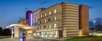 Un hotel de varios pisos con techo plano, logotipo de Marriott y un pilar de piedra en la fachada.