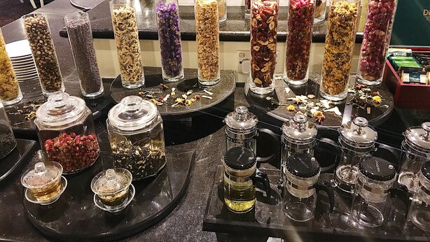 A variety of glass containers with dried flowers and herbs on a counter. - Sunway Hotel Hanoi (Hanoi)