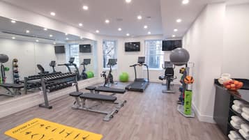 A modern gym with various exercise equipment, including treadmills, dumbbells, and exercise balls.
