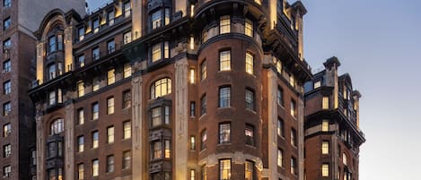 A multi-story hotel with a classic architectural style, featuring arched windows and decorative stonework.