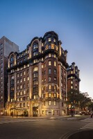 A multi-story hotel with a classic architectural style, featuring arched windows and decorative stonework.