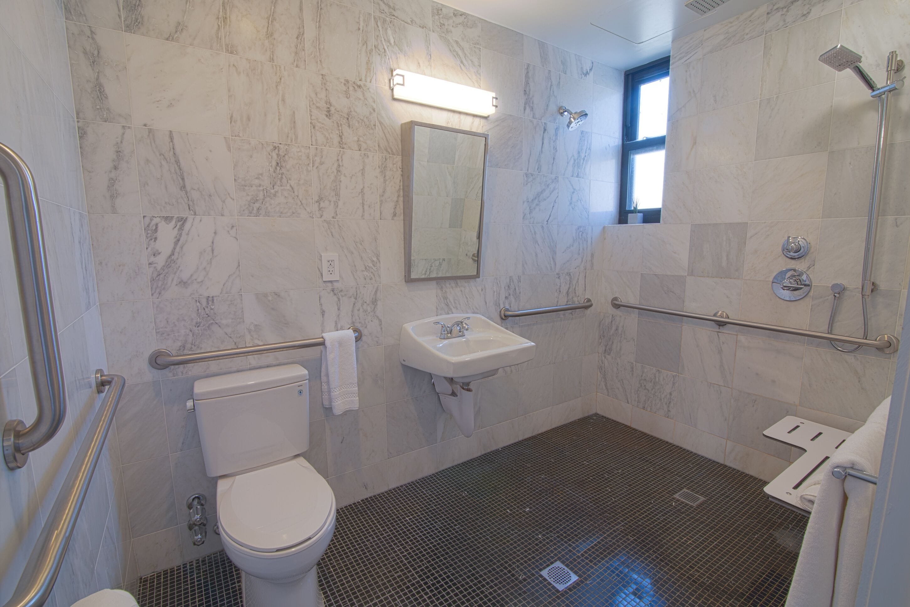 A bathroom with a toilet, sink, and shower area.