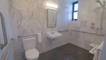 A bathroom with a toilet, sink, and shower area.