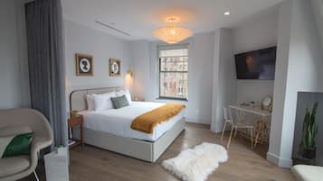 Een moderne slaapkamer met een groot bed, een bureau en een televisie.