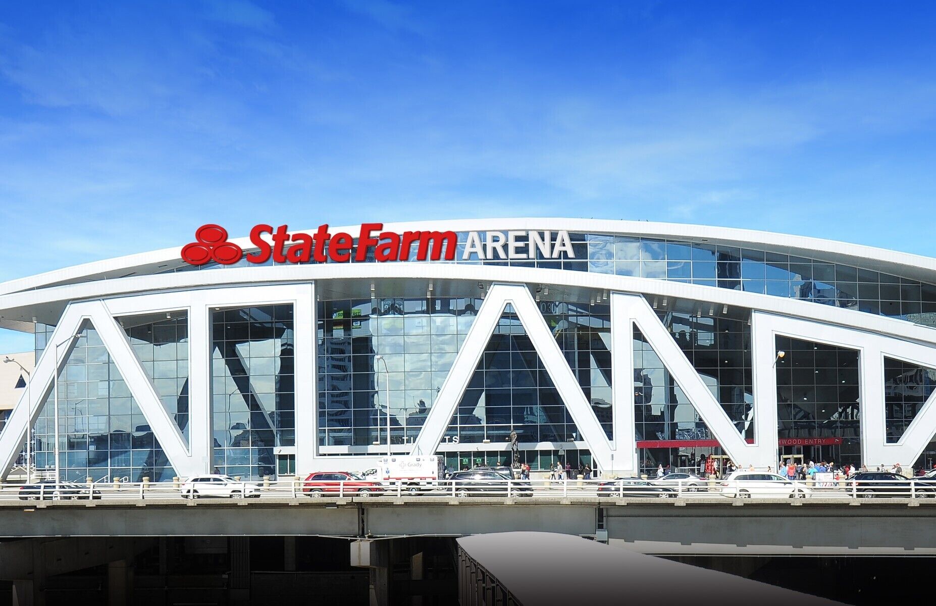 The State Farm Arena with a modern glass facade and a distinctive triangular design.