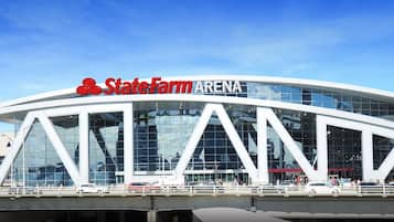 The State Farm Arena with a modern glass facade and a distinctive triangular design.