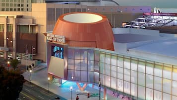 Een modern gebouw met een groot, rond, oranje dak, waarop 'College Football Hall of Fame' staat.