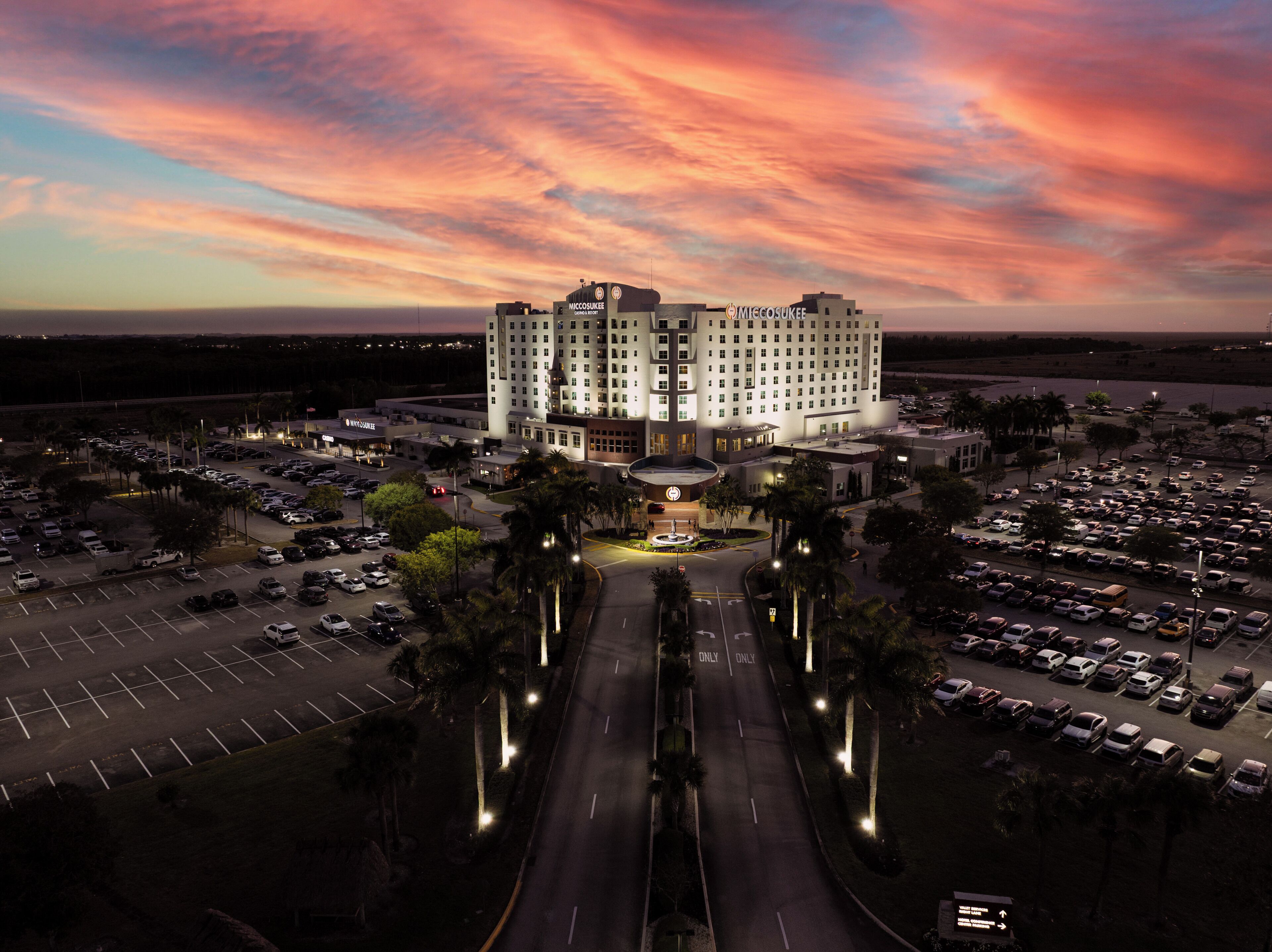 A hotel with a central courtyard, multiple parking lots, and a large building with a prominent entrance.