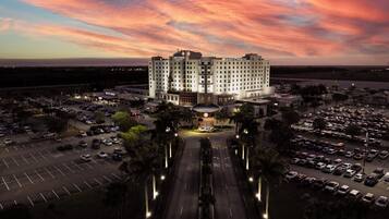 A hotel with a central courtyard, multiple parking lots, and a large building with a prominent entrance.