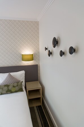 A neatly arranged hotel room with a bed, a bedside table, a lamp, and wall-mounted light fixtures. - Metro Hotel on Pitt - Sydney (Sydney)