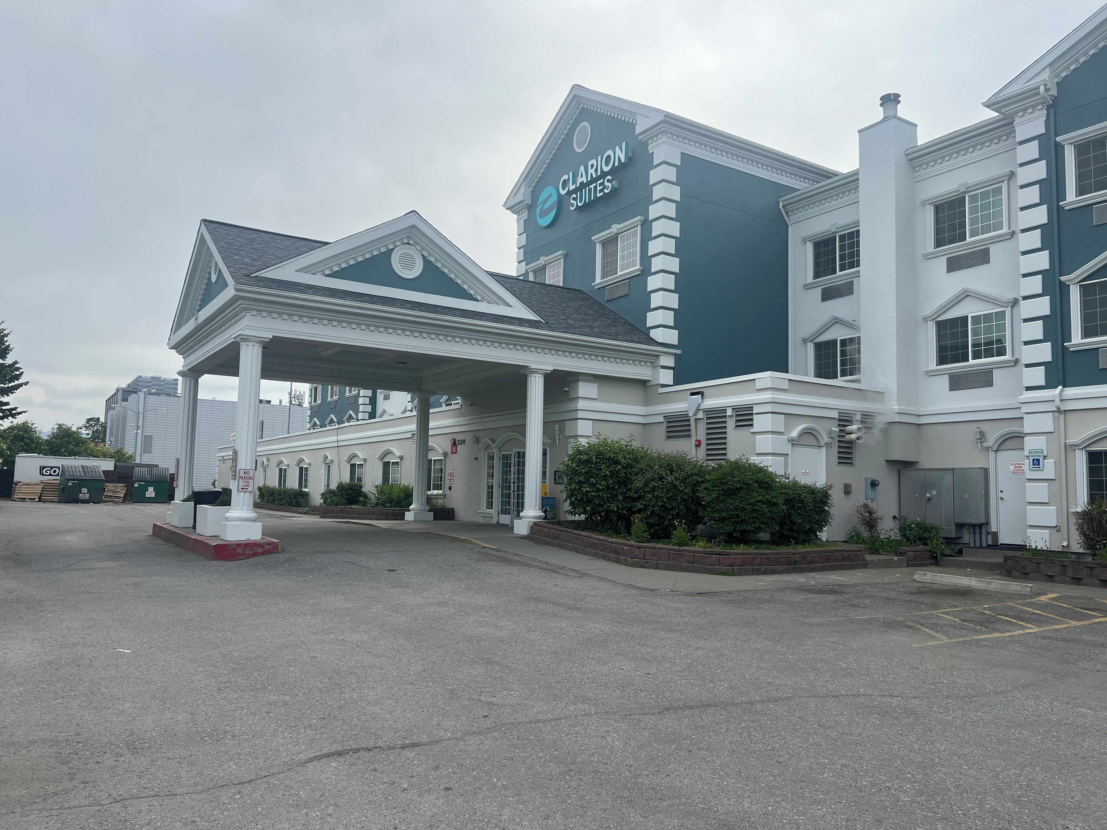 Un hotel con entrada cubierta, varias ventanas y un cartel de Clarion Suites.