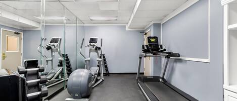 A gym with exercise equipment including treadmills, elliptical machines, and weight machines.