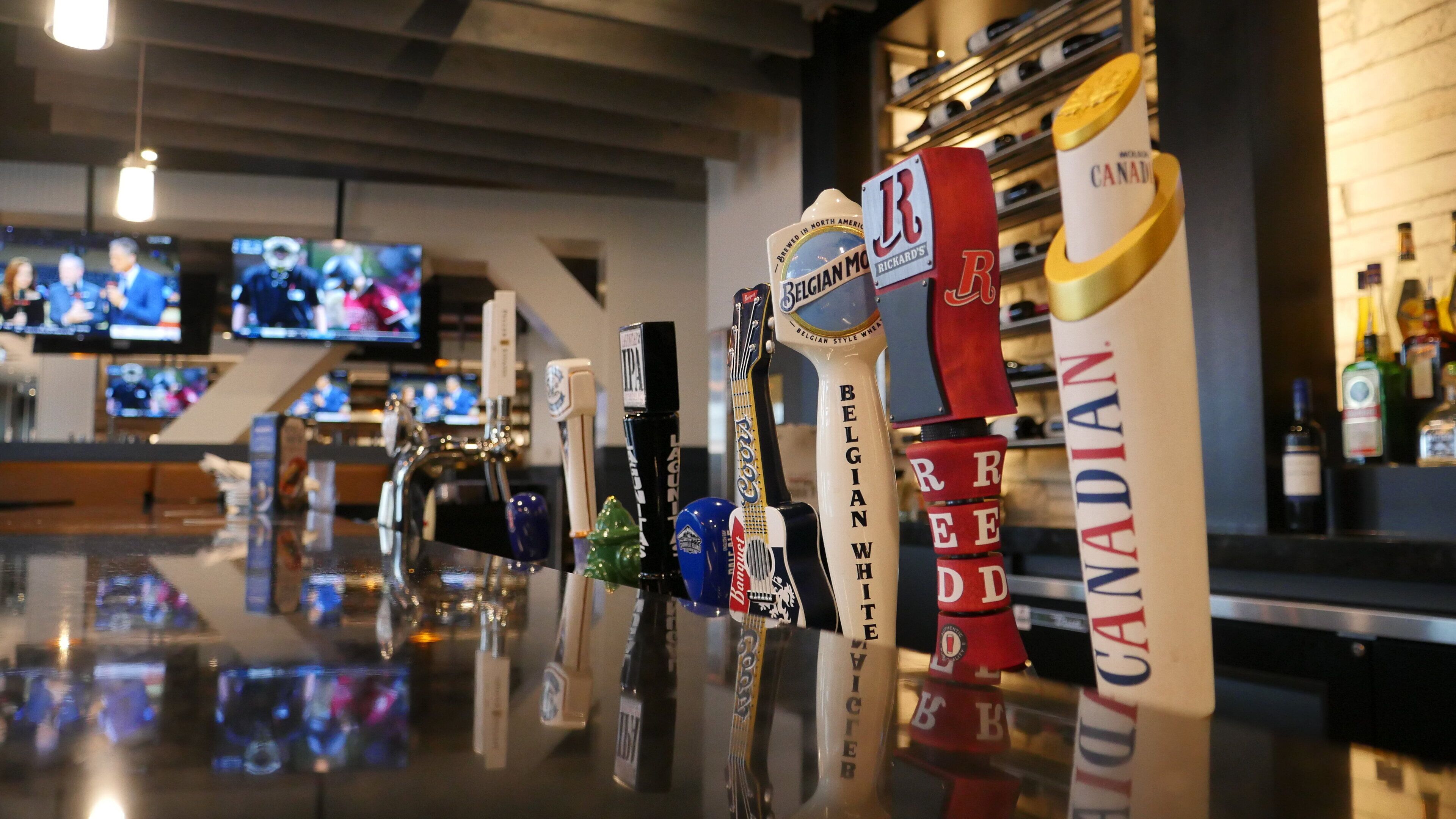 A bar area with various beer taps and bottles, including brands like Coors Light and Canadian.