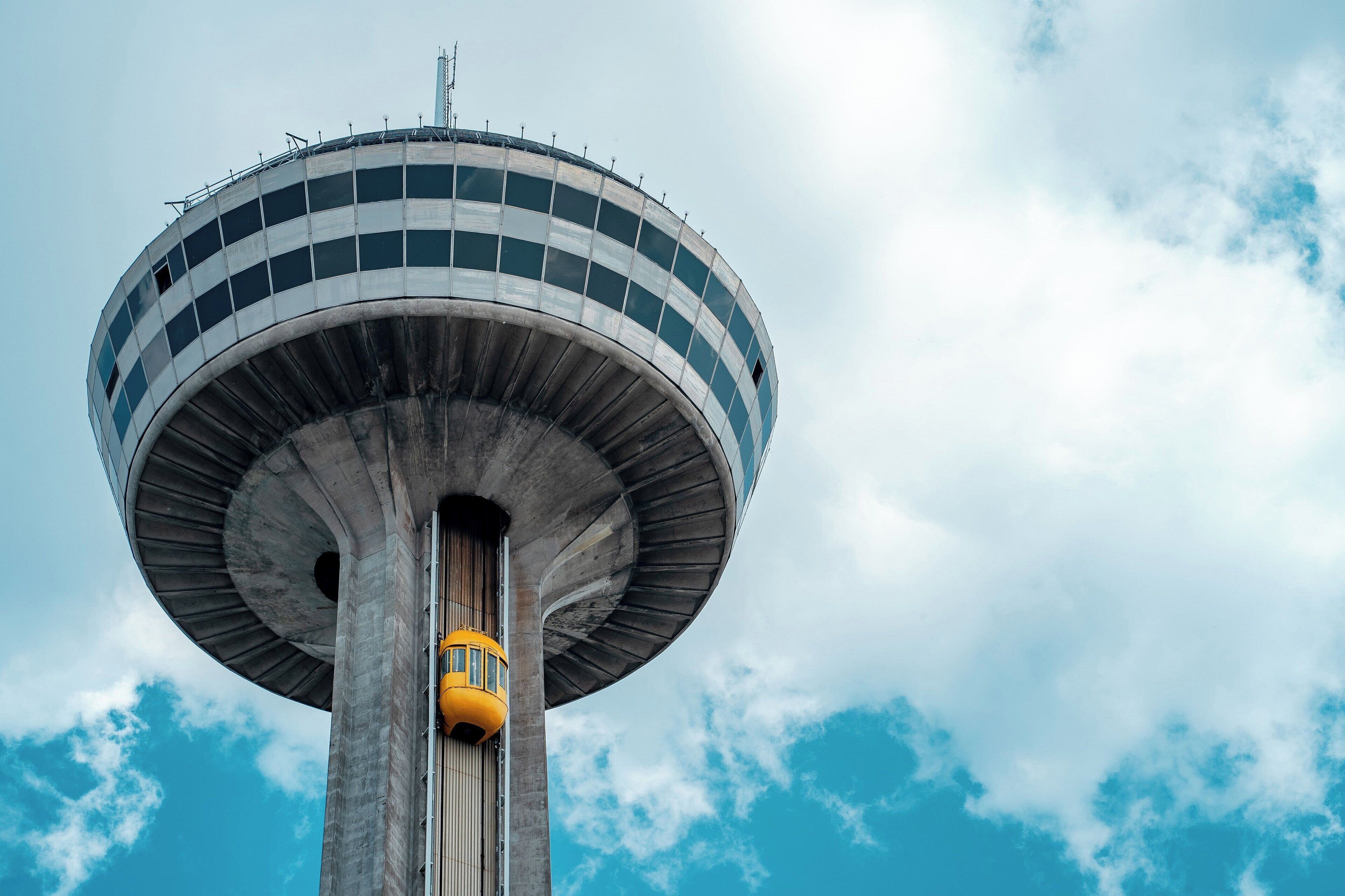 Uma torre alta e cilíndrica com um elevador amarelo.
