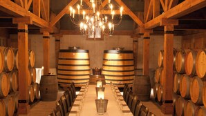 A long table set for a meal in a room with wooden barrel walls and a chandelier. - Niagara Fallsview Hotel (Niagara Falls)