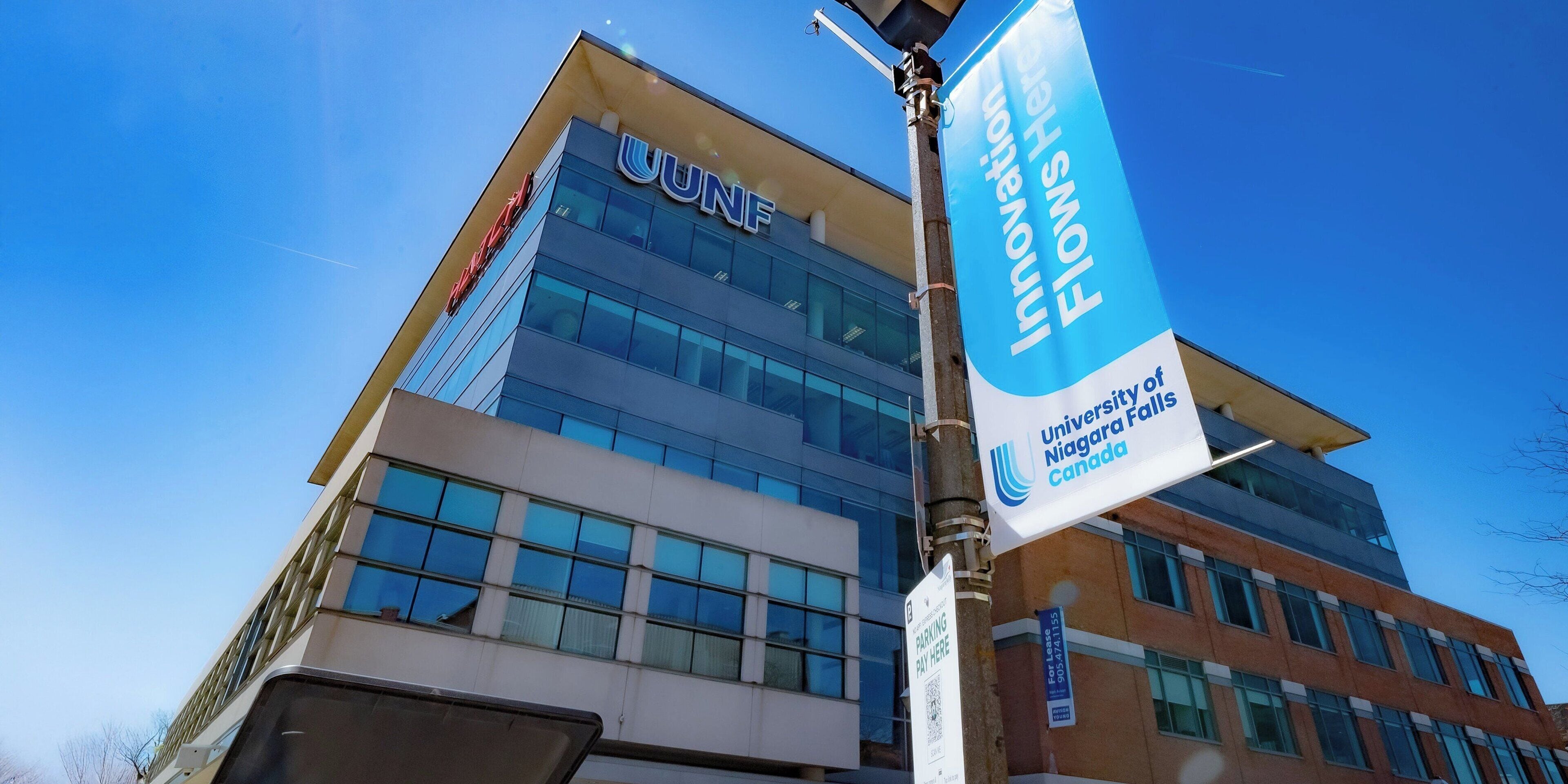 A modern building with the UNF logo and a banner stating "Innovation Flows Here" at the University of Niagara Falls, Canada.