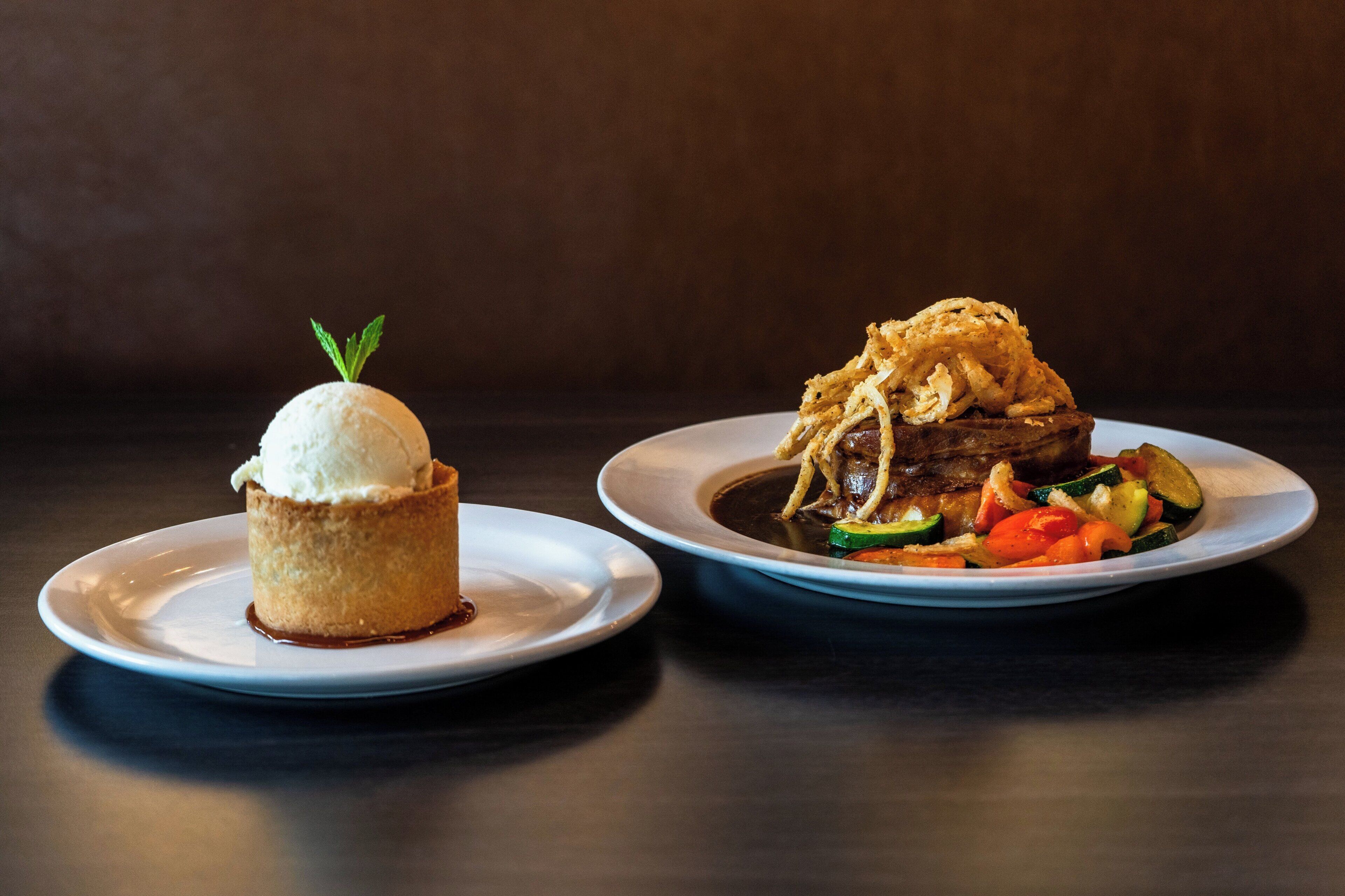 Two plates of food on a table.
