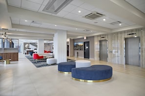 A modern lobby with a central seating area, a reception desk, and elevators. - Holiday Inn & Suites Chicago - Downtown by IHG (Chicago)