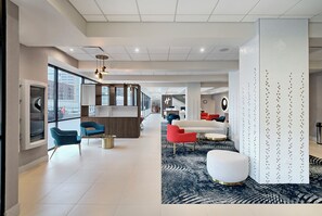 A modern interior with a reception desk, seating area, and a patterned carpet.