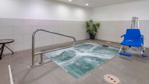 A swimming pool with a metal safety rail, a blue chair, and a potted plant. - Comfort Suites Fort Collins Near University (Fort Collins)