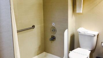 A bathroom with a glass-enclosed shower, a toilet, and a towel rack.