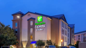 Ein Holiday Inn Express & Suites Hotel mit moderner Fassade, mehreren Parkplätzen und einem gut beleuchteten Eingang.