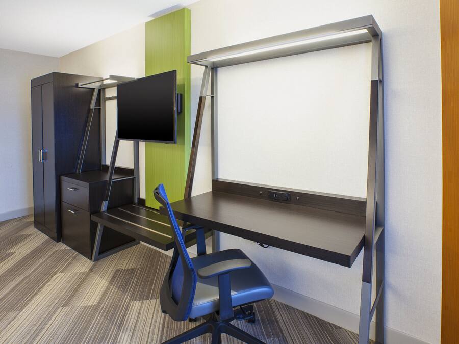 Un espacio de oficina moderno con un escritorio, una silla y un monitor de pantalla plana.