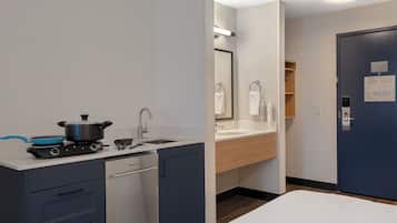 A compact kitchen with a stove, sink, and dishwasher.