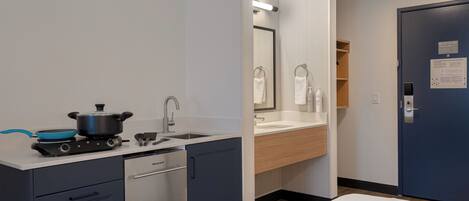 A compact kitchen with a stove, sink, and dishwasher.