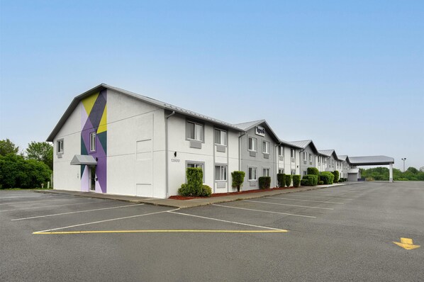 A row of motel buildings with a parking lot in front. - Spark by Hilton West Coxsackie (West Coxsackie)