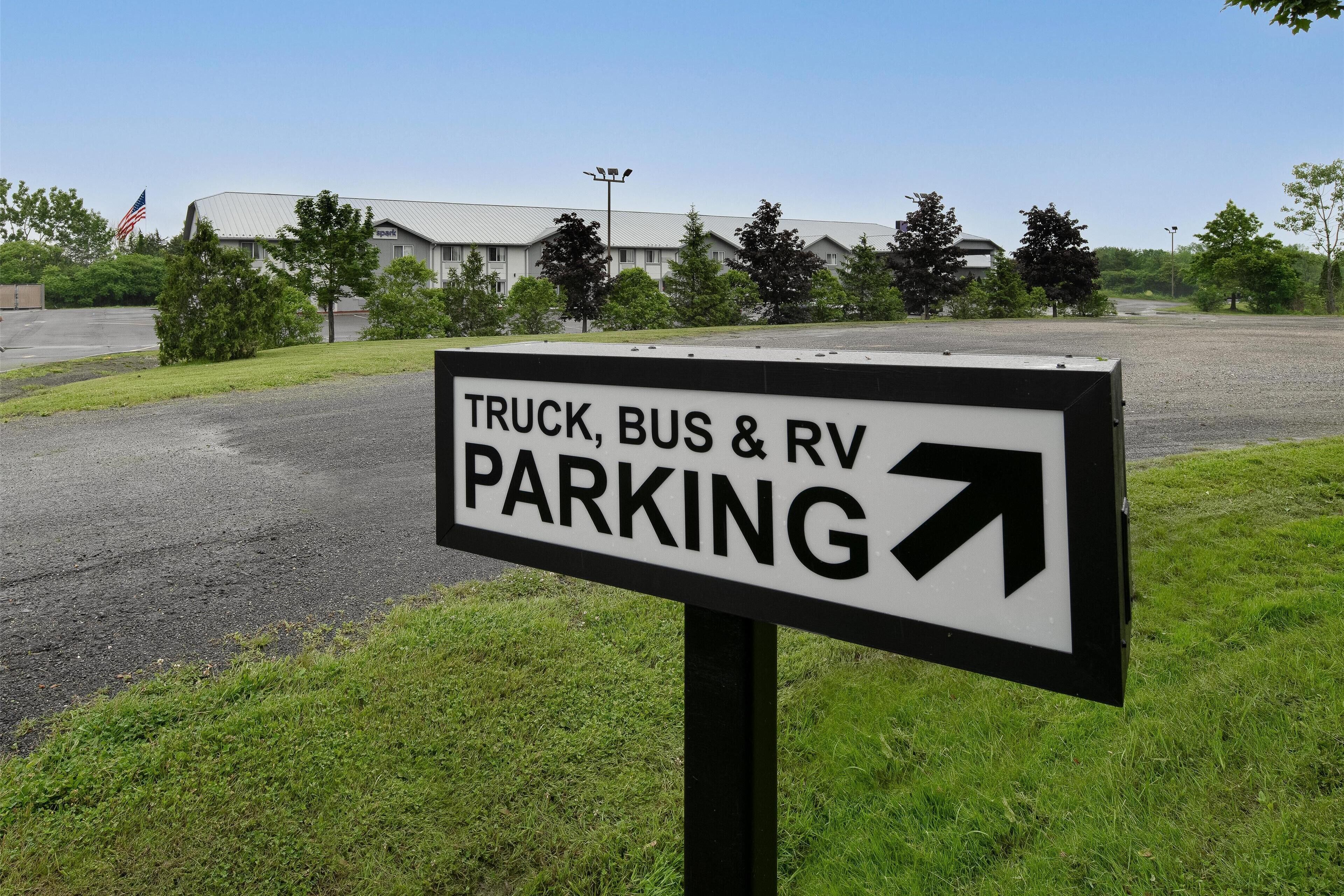 Un panneau indiquant un espace de stationnement réservé aux camions, aux autobus et aux véhicules récréatifs, avec une flèche pointant vers la droite.