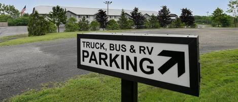 Un panneau indiquant un espace de stationnement réservé aux camions, aux autobus et aux véhicules récréatifs, avec une flèche pointant vers la droite.