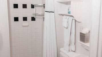 A bathroom with a white toilet, a sink, and a shower.