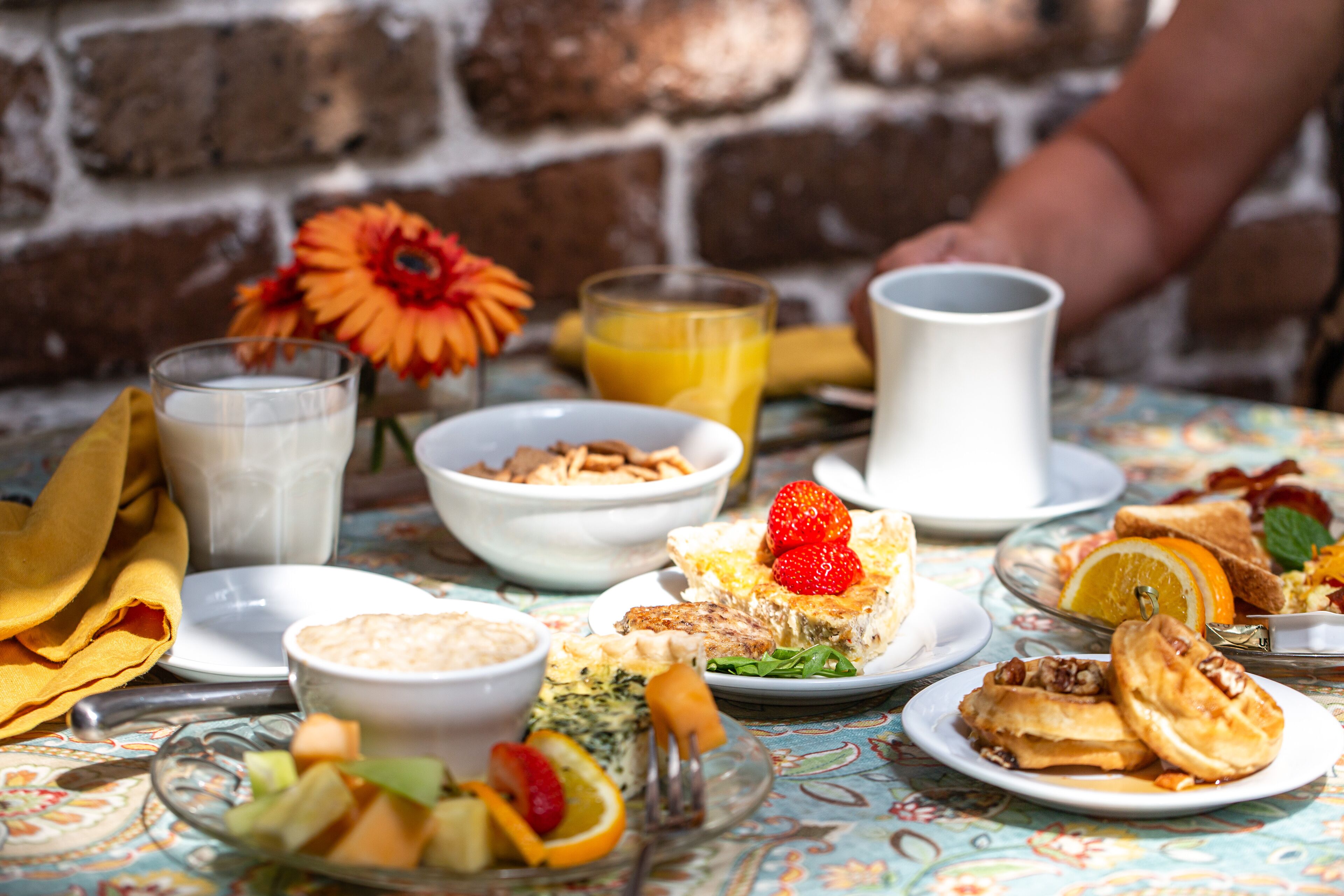 Ein Frühstückstisch mit verschiedenen Speisen, darunter Pfannkuchen, Toast und Obst.