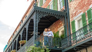 A balcony with ornate metal railings and hanging flower baskets. - The Marshall House, Historic Inns of Savannah (Savannah)