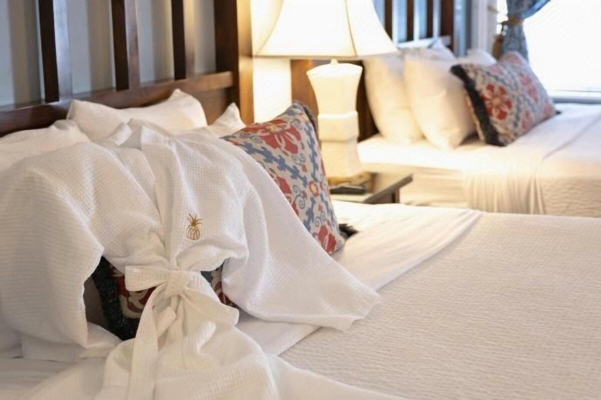 Une chambre d’hôtel avec un lit, des oreillers et une lampe.