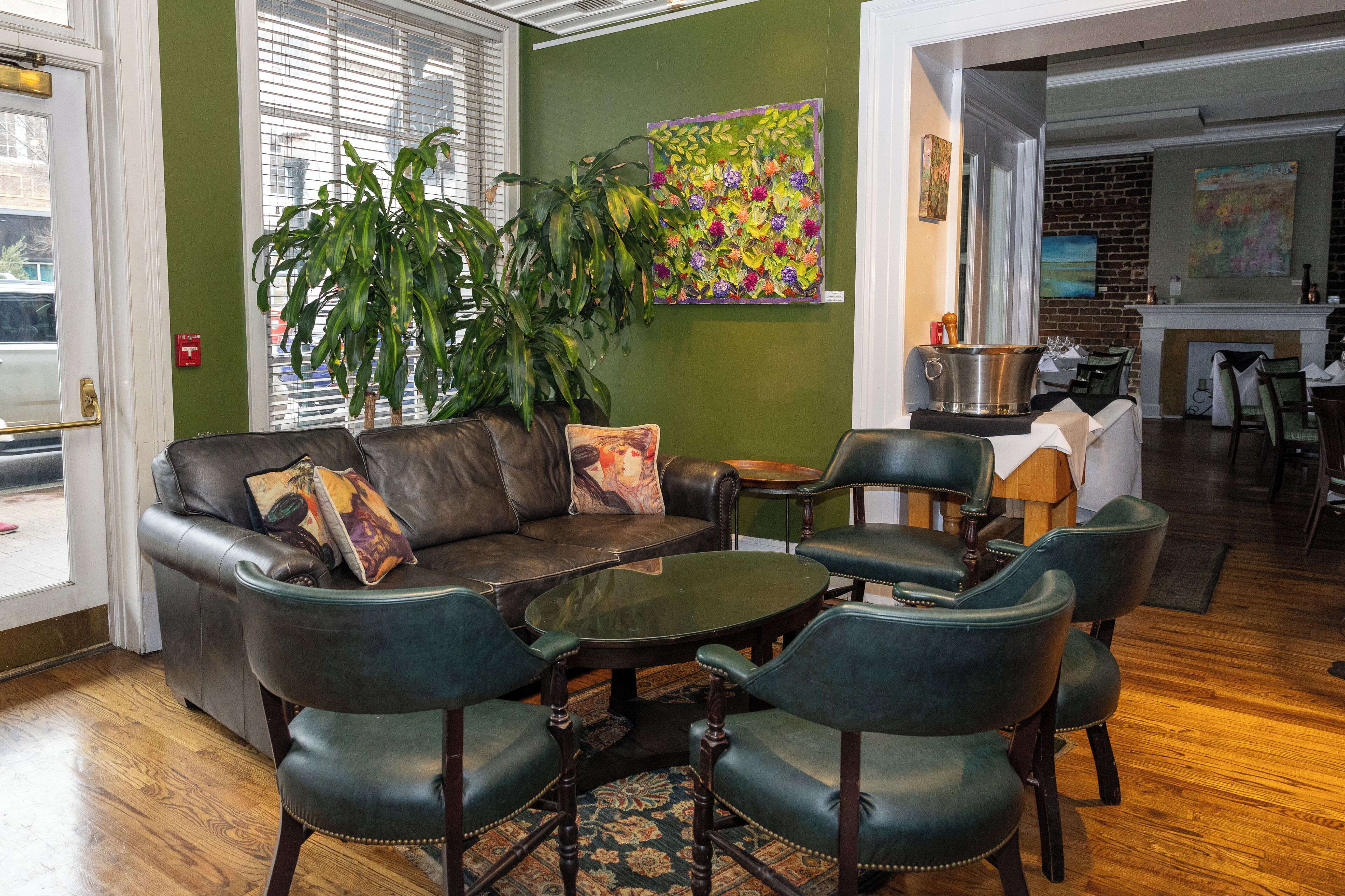 A cozy seating area with leather furniture, a coffee table, and a large plant.